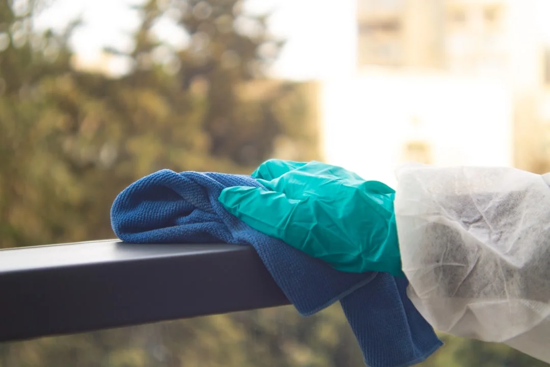 Une personne équipée d’un équipement de protection individuelle passe l’aspirateur en intérieur, pour garantir un nettoyage minutieux.